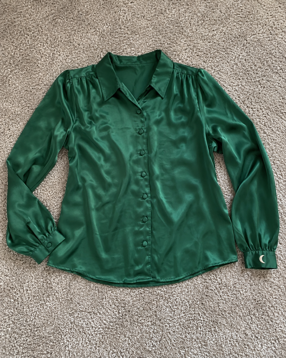 Synthetic emerald satin blouse photographed as an ordinary flat-lay for the test